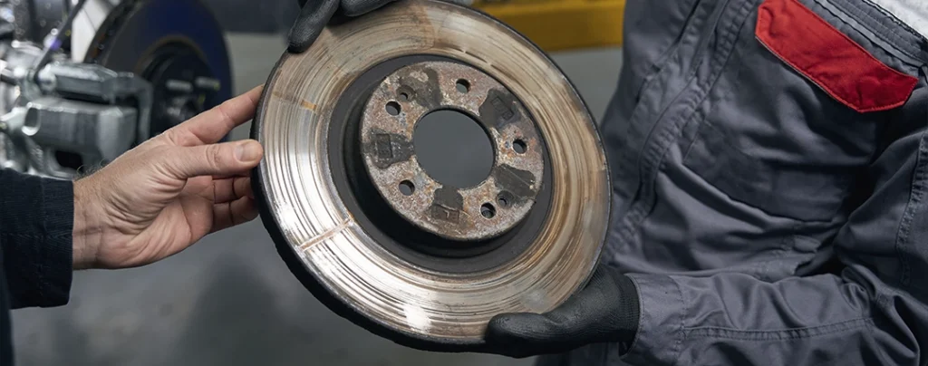 Disco de freio com desgaste irregular e sinais de superaquecimento, indicando necessidade de substituição.